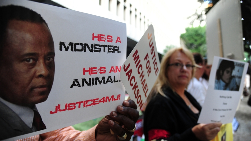 Supporters at the late pop star Michael Jackson hold signs outside Los Angeles Superior Court