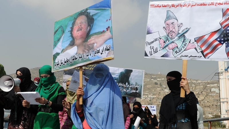Afghan protestors hold placards as they shout anti-US slogans during a demonstration against the invasion