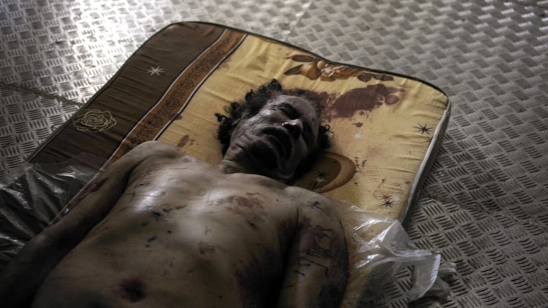 The body of the ousted Libyan strongman Moammar Gadaffi lies in a freezer