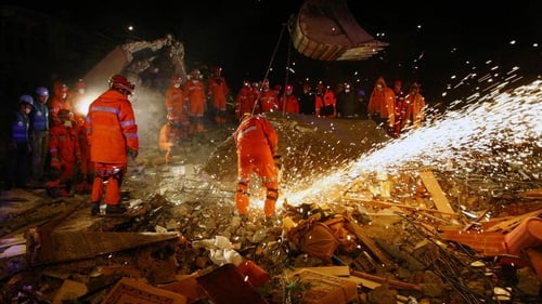Members of the Turkish army try to reach people trapped under the rubble of a collapsed building