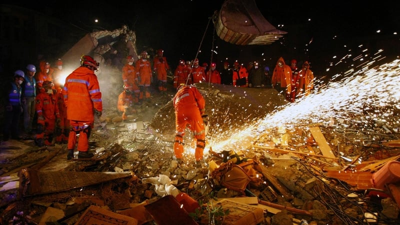 Members of the Turkish army try to reach people trapped under the rubble of a collapsed building