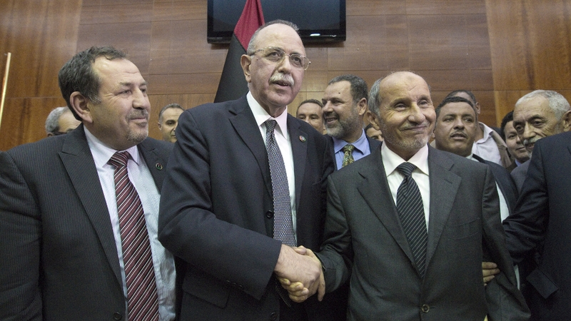 Libya's new Prime Minister (centre) is congratulated by the NTC chairman (right)