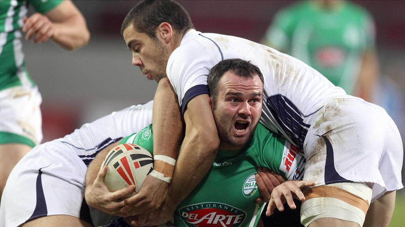Ireland's Paul Handforth is wrapped up by the French defence