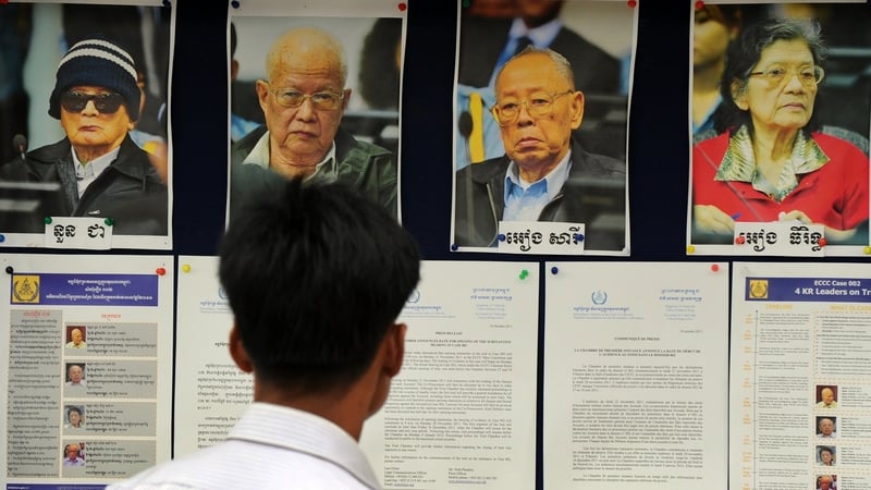 A Cambodian man looks at pictures of Nuon Chea, Khieu Samphan, Ieng Sary &amp; Ieng Thirith