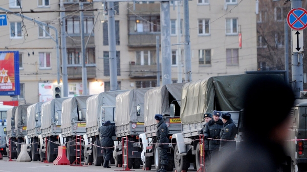 Police and interior ministry troops stand beside their vehicles in central Moscow