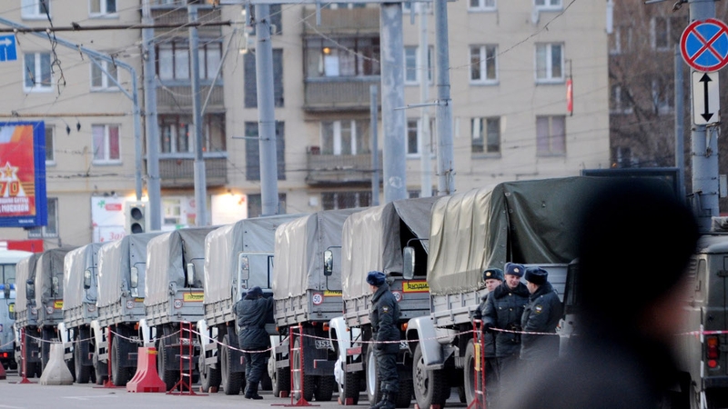 Police and interior ministry troops stand beside their vehicles in central Moscow