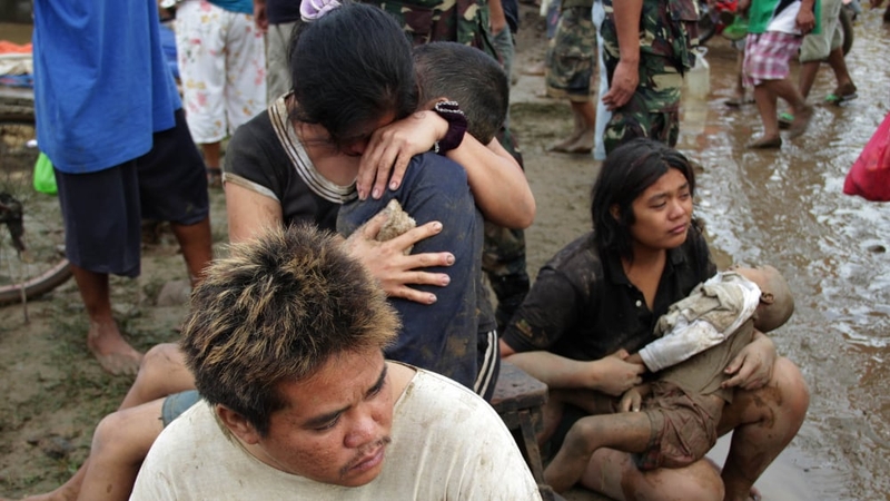 Two women hold their children killed during the passage of tropical storm Washi