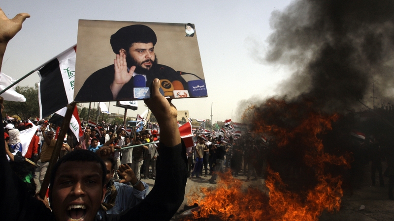 A supporter of Iraqi Shiite radical leader Moqtada al-Sadr holding his picture