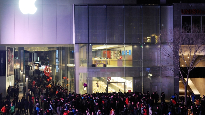 People wait outside an Apple store all night prior to the mainland release of iPhone 4S in Beijing