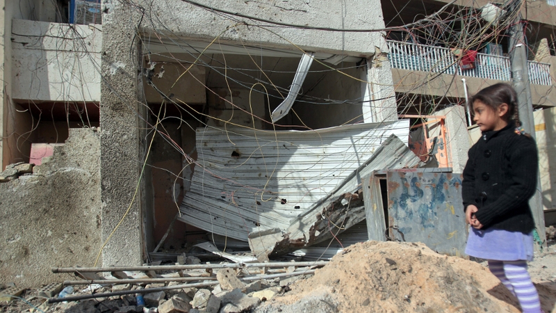 A young girl inspects the damage following a blast in north Baghdad