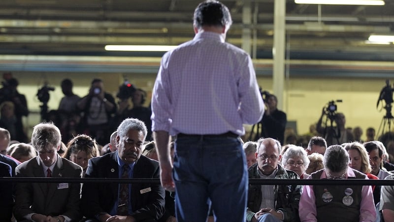 Republican presidential candidate Mitt Romney and supporters observe a moment of silence for Ohio tornado victims before speaking during a campaign rally at US Aeroteam in Dayton, Ohio