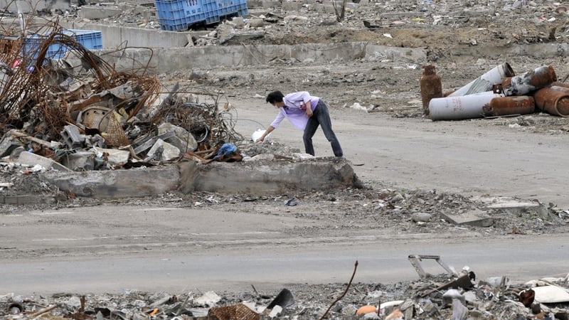 A women lays flowers for the victims in Kesennuma