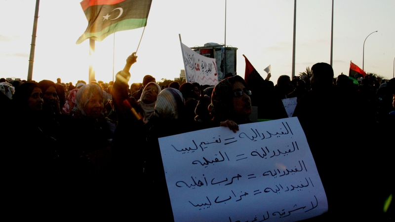 Protesters wave the national flag and shout slogans during a demonstration