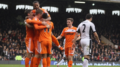 Swansea players celebrate as Ireland international Stephen Kelly walks away dejected