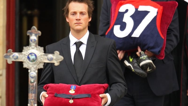 Media personality Jules Lund carries the Brownlow Medal of Jim Stynes, won in 1991
