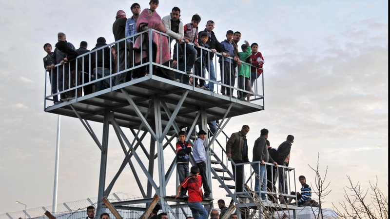 Syrian refugees watch the border from Oncupinar refugee camp