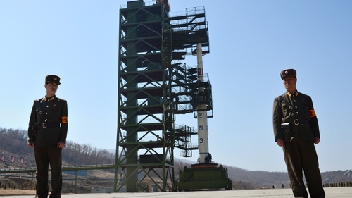 North Korean soldiers stand guard in front of the Unha-3 rocket at Tangachai-ri space centre