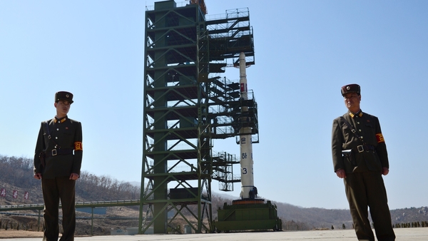 North Korean soldiers stand guard in front of the Unha-3 rocket at Tangachai-ri space centre