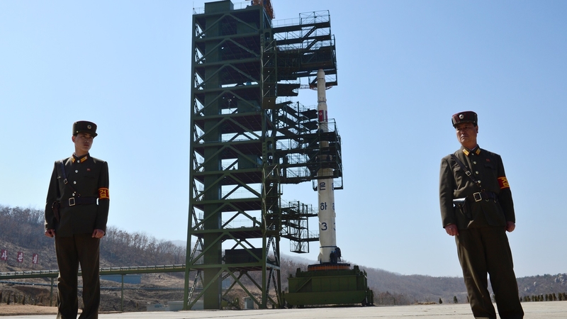 North Korean soldiers stand guard in front of the Unha-3 rocket at Tangachai-ri space centre