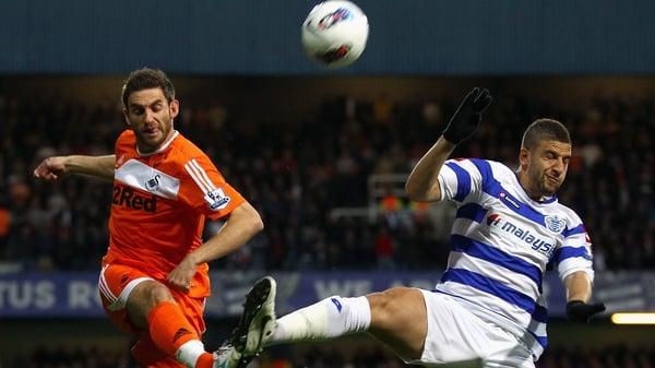 Swansea's Angel Rangel and Adel Taarabt of QPR battle for the ball