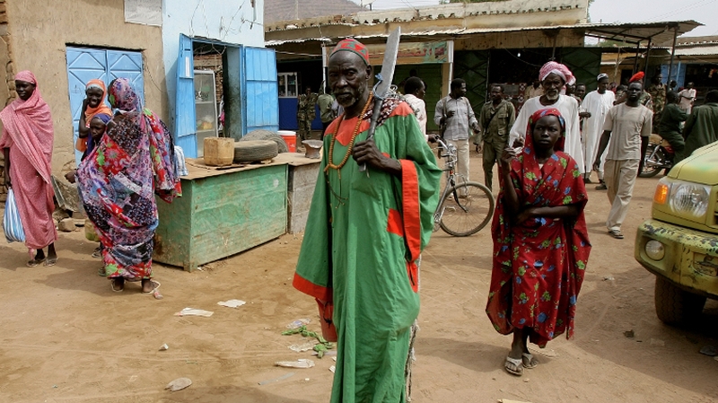 A Sudanese man walks with a machete in a market area following clashes between the army and South Sudan's forces in the town of Talodi