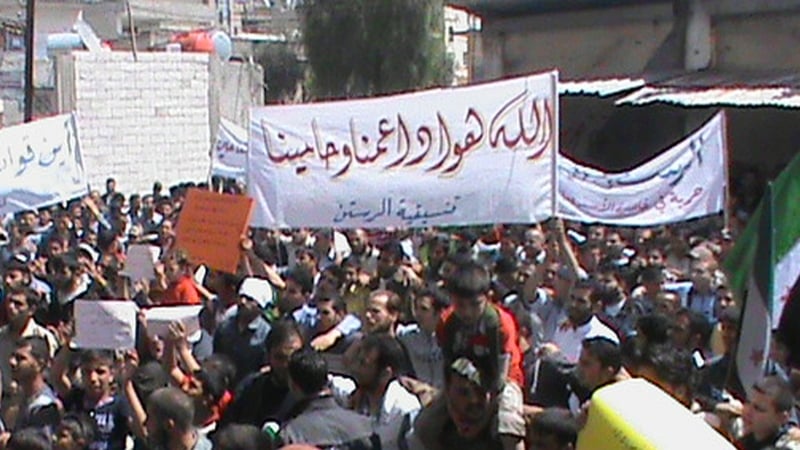 Syrian protesters holding slogans during an anti-regime demonstration