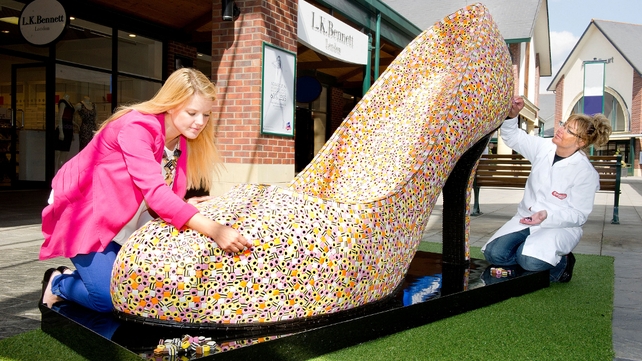 A sweet maker and style consultant put the final touches on a 22,000-Liquorice Allsorts shoe in England
