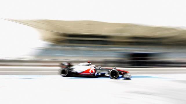 Jenson Button of McLaren drives down the pit lane during practice for the Bahrain Formula One Grand Prix at the Bahrain International Circuit