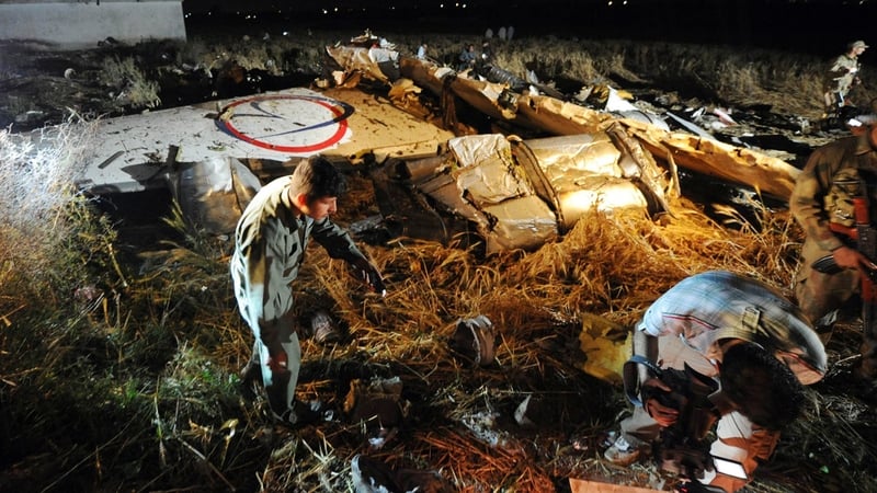 Pakistani army soldiers search through debris following the crash