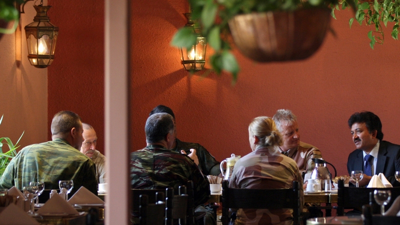 Niraj Singh (r), spokesman of the UN observers team in Syria, speaks with the observers during breakfast at a hotel in Damascus today