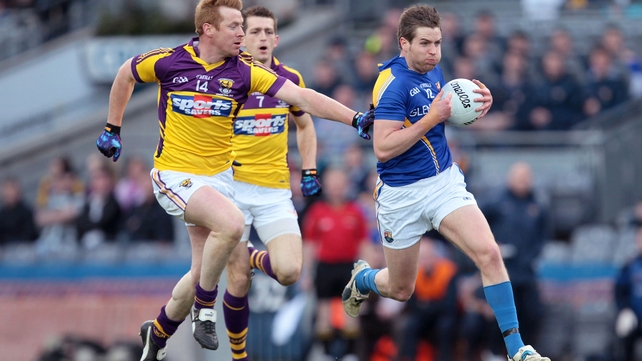 Longford's Niall Mulligan breaks through under the watchful eye of Wexford's Eric Bradley