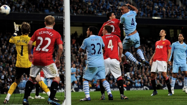 Vincent Kompany rises highest to power home a first-half header to give City victory in the Manchester derby