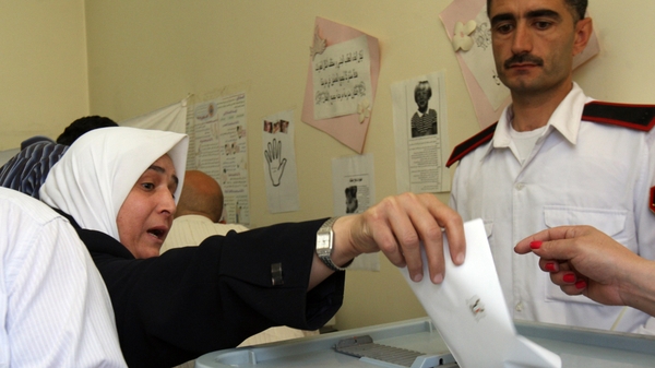 A Syrian woman casts her vote in the country's parliamentary election