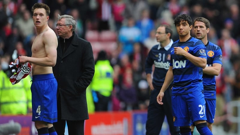 (L-R) Phil Jones, Sir Alex Ferguson, Rafael Da Silva and Michael Owen look dejected as the crowd react to the winning goal at Manchester City