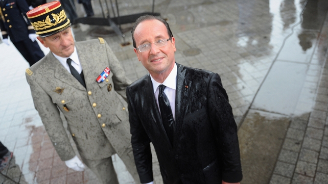 A rain-drenched French President Francois Hollande attends a ceremony to the Unknown soldier at Arc de Triomphe