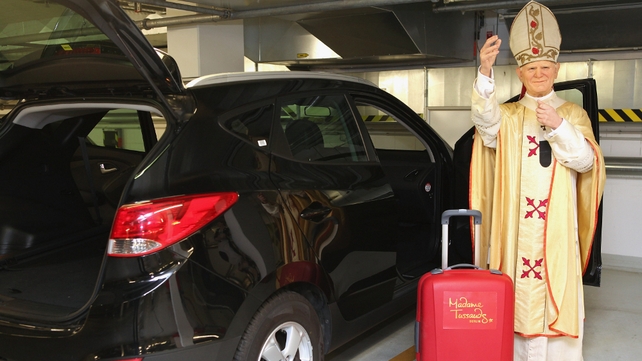 A wax figure of Pope John Paul II stands in a car park prior to being loaded into a car to be driven to Wadowice, Poland