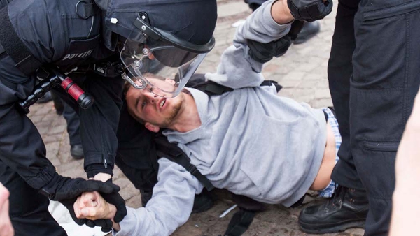 German riot police carry a protester after the dissolution of an unauthorised rally in front of city hall