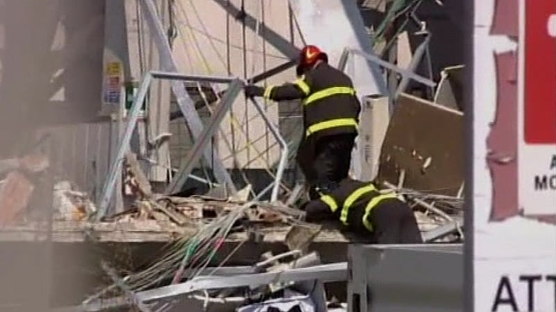 Rescuers search through rubble of collapsed buildings