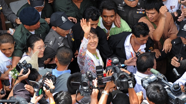 Aung San Suu Kyi waves to crowds in Thailand on her first overseas trip from Burma, officially known as Myanmar, in more than two decades