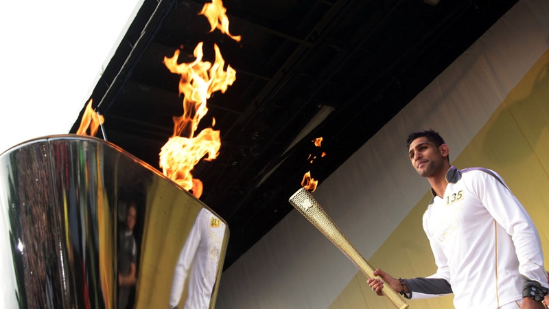 Boxer Amir Khan lights the cauldron with the Olympic Flame at the end of the relay leg through Bolton