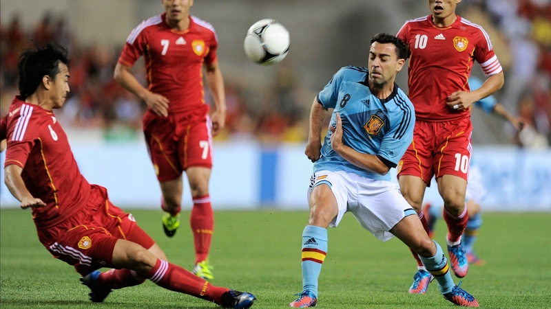 Xavi Hernandez (R) of Spain is cut off by China's Feng Xiaoting