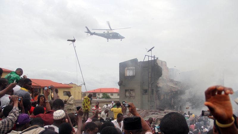 A helicopter hovers over the crash site