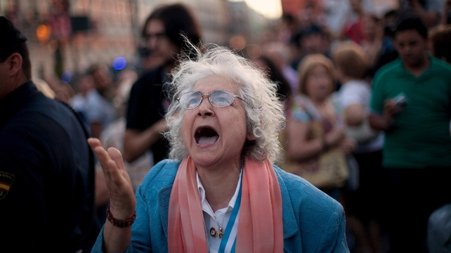 A woman complains about the noise of banging pots during a bailout protest in Madrid