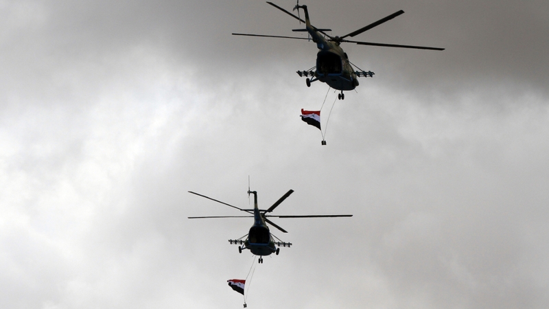 Syrian army MI 18 helicopters fly over demonstrators during a rally to support President Bashar al-Assad in March