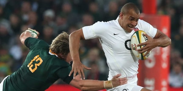 Jonathan Joseph of England is tackled by Jean de Villiers