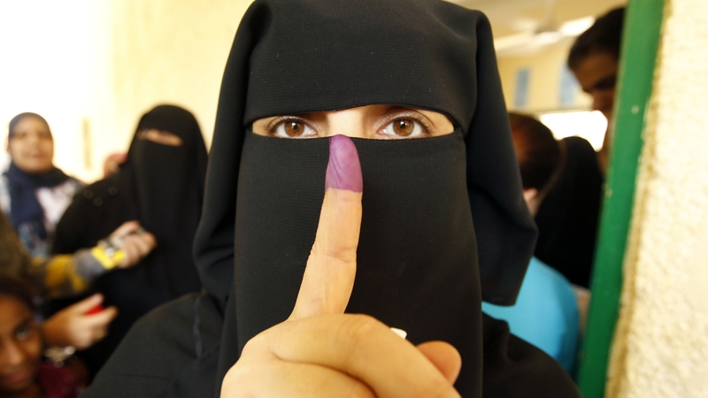 An Egyptian women shows her ink-stained finger after voting at a polling station in Cairo