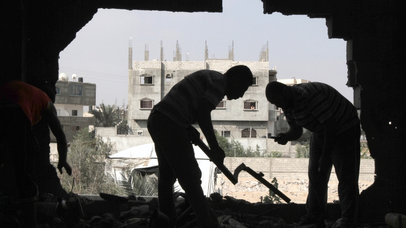 Palestinians inspect the damage following the Israel strike