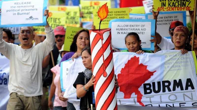 Demonstrators carry a giant replica of a birthday candle to celebrate the 67th birthday of Aung San Suu Kyi during a protest in front of the Burmese Embassy in Manila