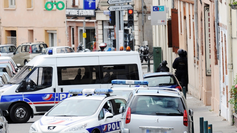 French police stand guard outside the bank where the stand-off took place