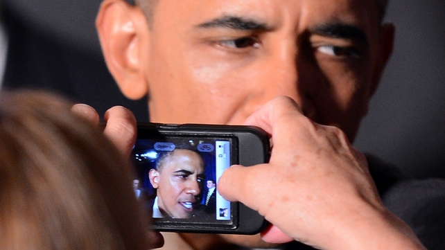 A supporter takes pictures of US President Barack Obama with her phone during an Obama Victory Fund Reception in Atlanta, Georgia
